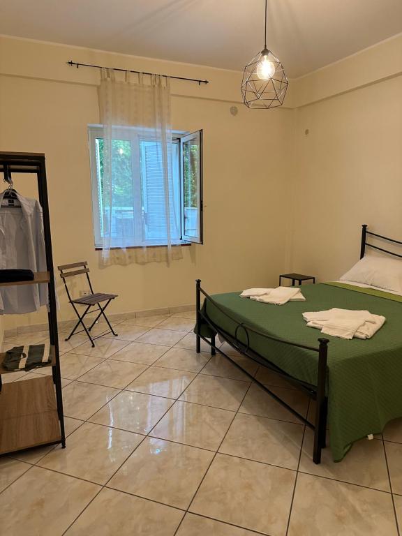 Un dormitorio con una cama verde y una ventana en in famiglia casa vacanze, en Sant'Egidio del Monte Albino