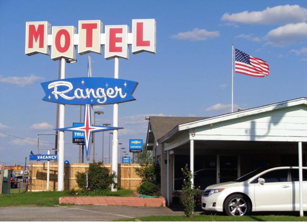 um sinal de motel em frente a um concessionário de carros em Ranger Motel em El Reno
