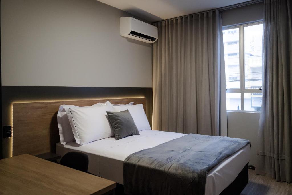 een hotelkamer met een bed en een raam bij Cidade das Bicicletas in Joinville