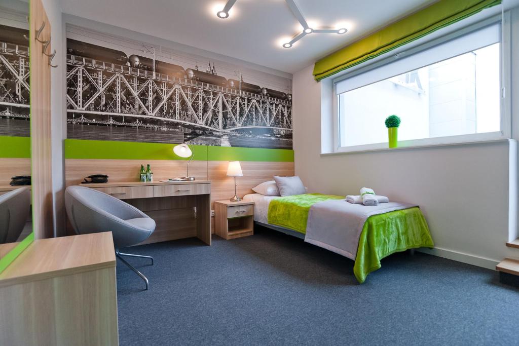 Green Hotel Płock في بلوك: غرفة نوم بسرير ومكتب ونافذة