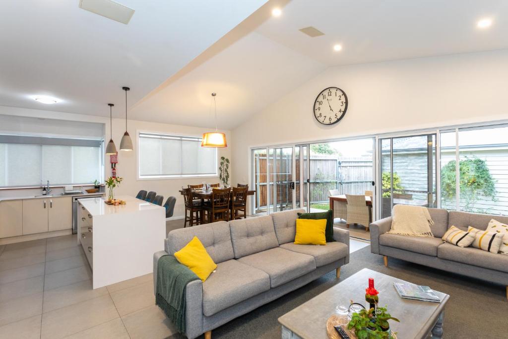 a living room with two couches and a kitchen at Armidale Cottage - House 1 in Armidale