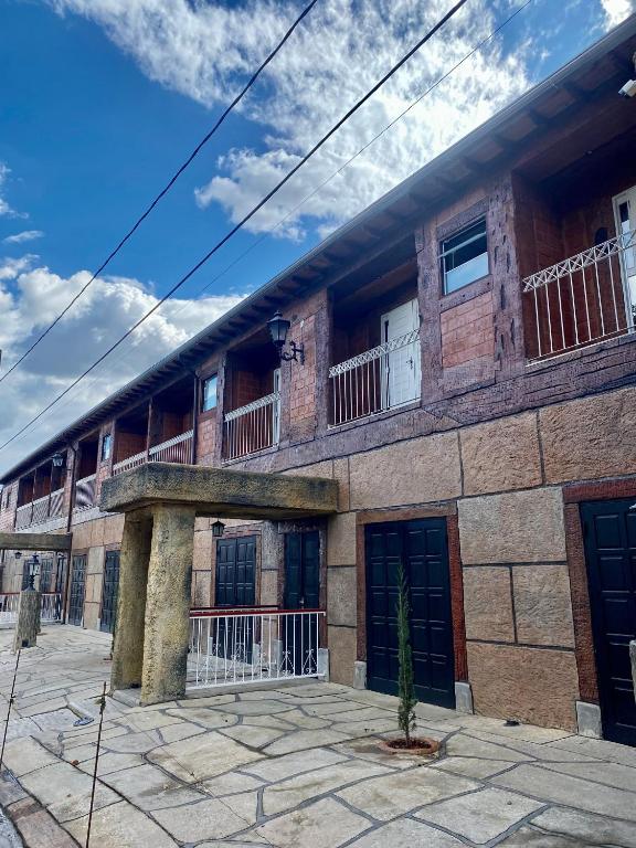 a large brick building with two balconies on it at Apartamentos a 200m do centro - Hospedaria Villa da Pedra in Tiradentes