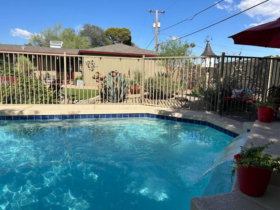 a swimming pool in front of a fence at Encanto Cactus Flower Casita in Phoenix