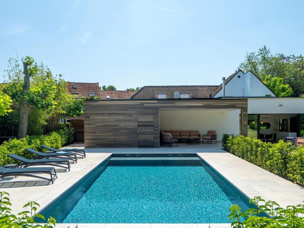 Luxury holiday home in Kortrijk with wellness and heated pool في كورتريك: مسبح في الحديقة الخلفية للمنزل