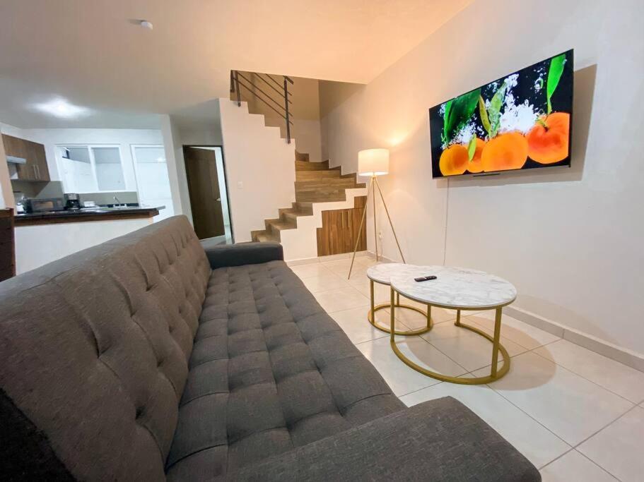 a living room with a couch and a table at Modern gated townhouse 5 min from Plaza Altozano in Morelia