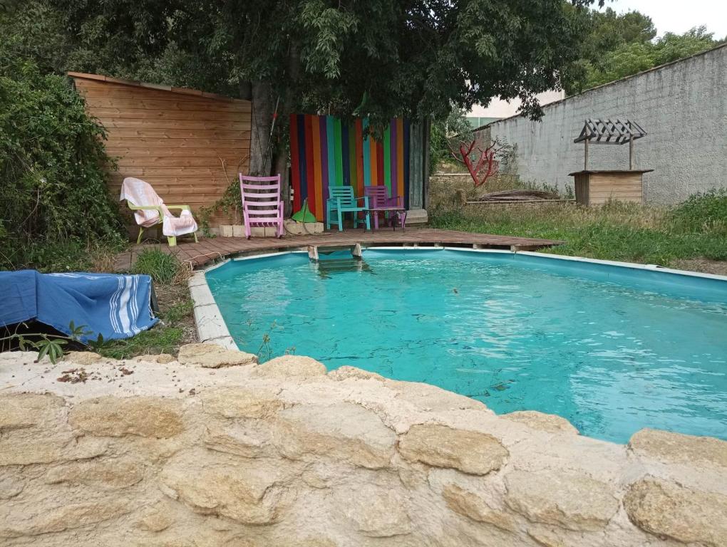 - une piscine avec des chaises et une table dans la cour dans l'établissement le gite d'Alice, à Vacqueyras