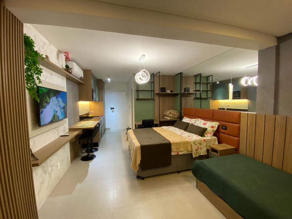 a hotel room with a bed and a desk and a bedroom at Studio Patteo Bosque Maia in Guarulhos