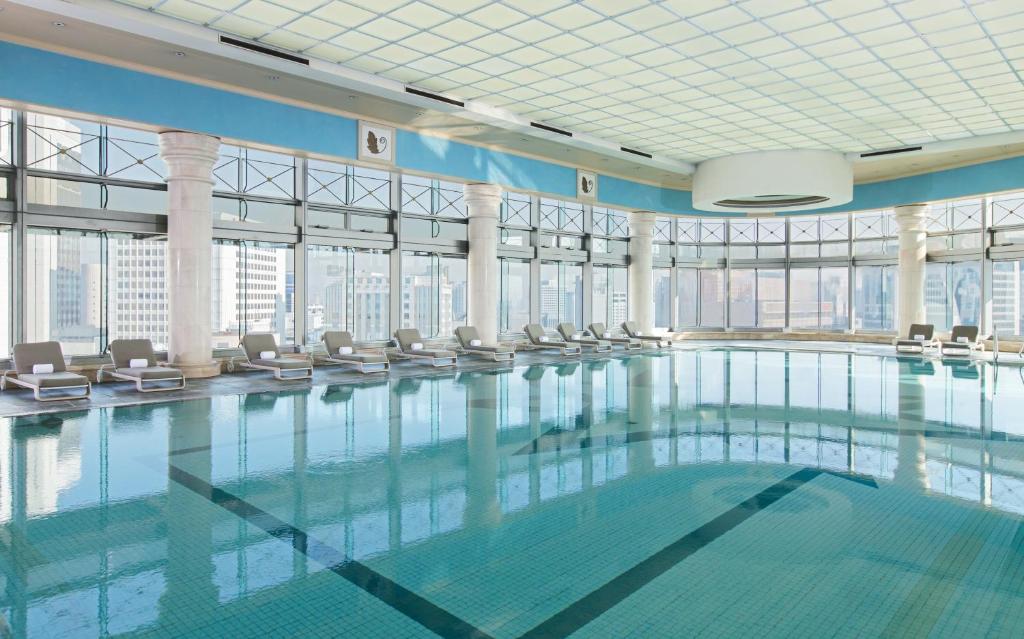 a swimming pool in a building with windows at THE PLAZA Seoul, Autograph Collection in Seoul