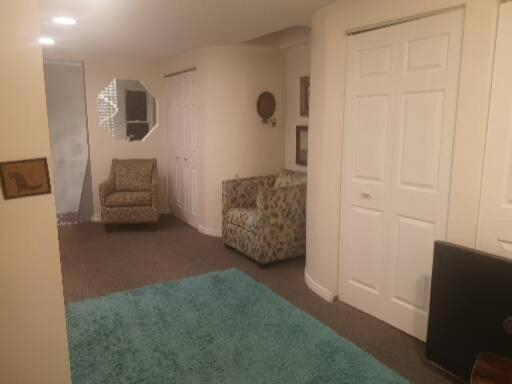 sala de estar con puerta, sofá y alfombra en Paradise Inn en North Bay
