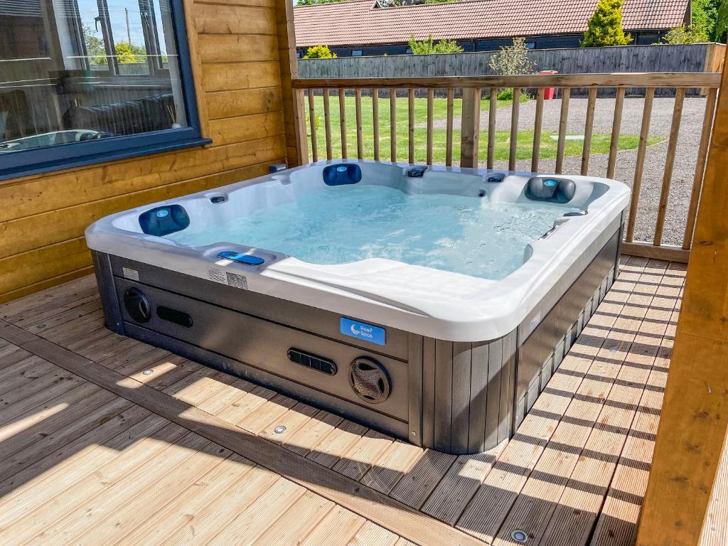 a hot tub sitting on top of a deck at Aylesbury Lodge in Halstead