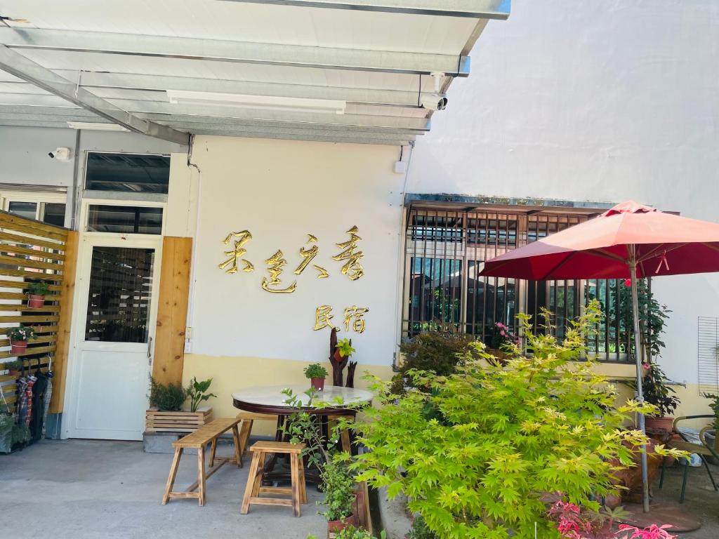 een patio met een tafel en stoelen en een parasol bij Nantou Fruit House in Renai