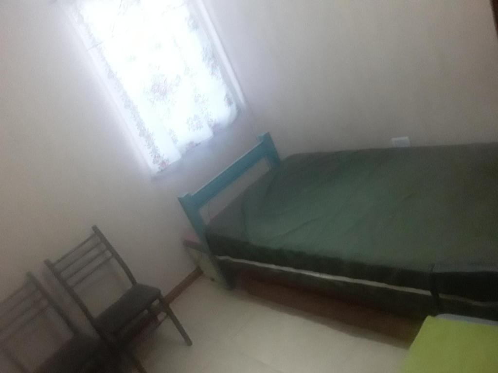 1 dormitorio con 1 cama, ventana y 2 sillas en Cabaña Omnia en Pocito