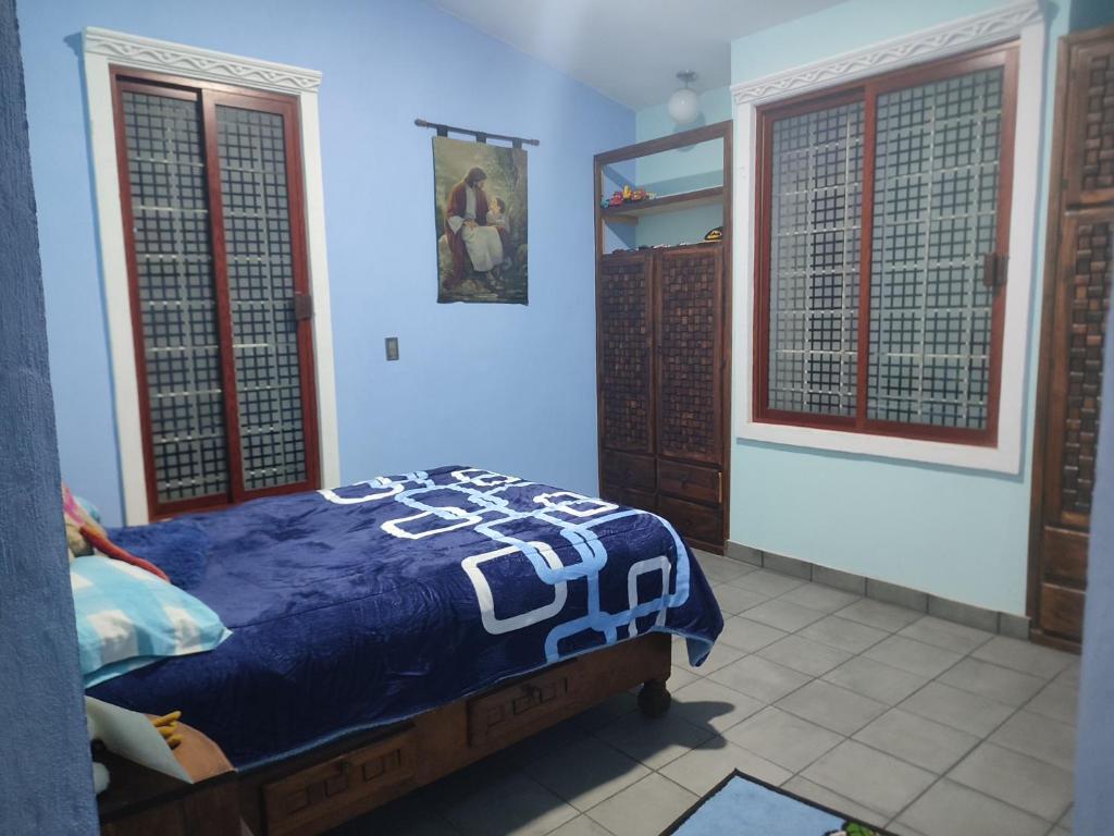 een slaapkamer met een bed met een blauwe deken erop bij Casa García 