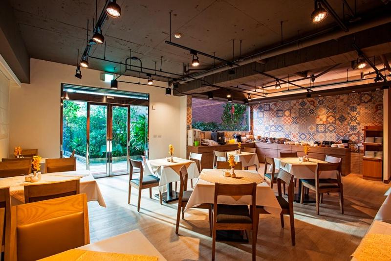 a restaurant with tables and chairs in a room at Citizen Hotel in Taipei
