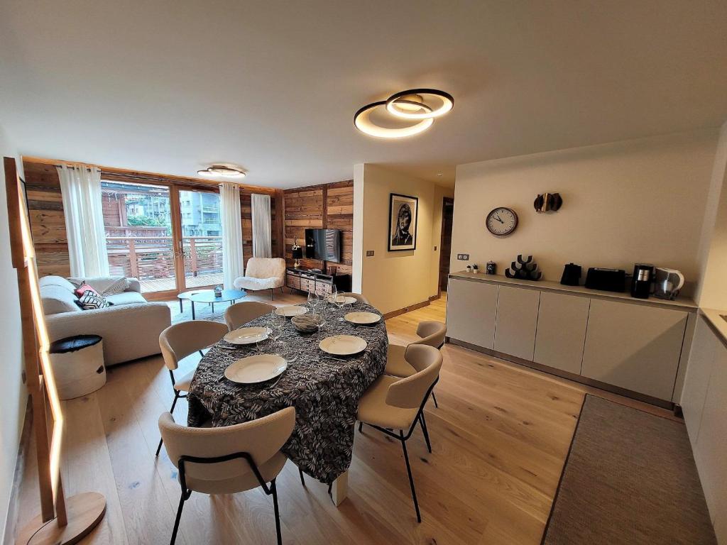 une cuisine et un salon avec une table et des chaises dans l'établissement Appartement prestige 6 pers, centre Les Gets, à 150m des pistes, avec terrasse et équipements luxueux - FR-1-598-147, aux Gets