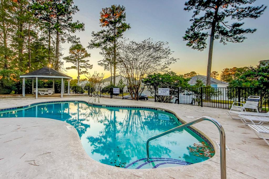 a swimming pool with chairs and a gazebo at Fairway Village Paradise in Myrtle Beach