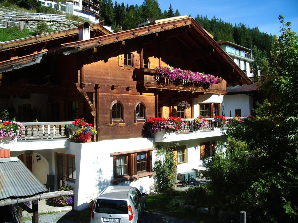 una casa con cajas de flores en sus balcones en Haus Rali, en Sankt Anton am Arlberg