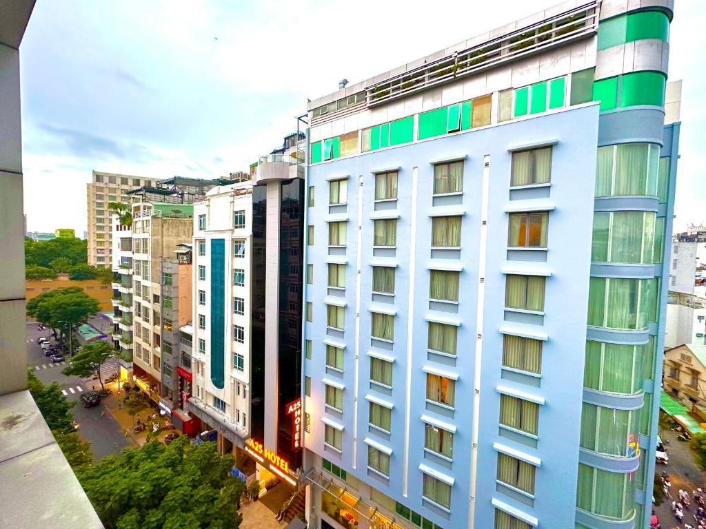 a tall white building with many windows in a city at SANG Hotel Apartment Sai Gon in Ho Chi Minh City