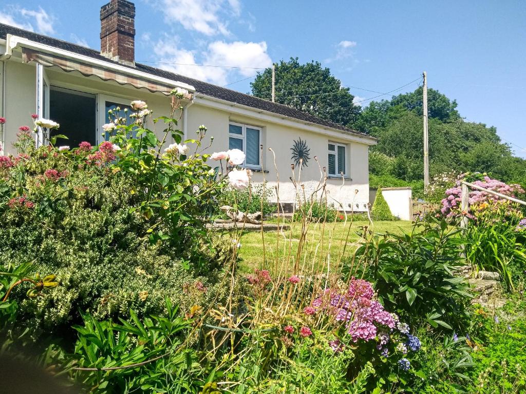 a garden in front of a house with flowers at Rivendell in Blakeney