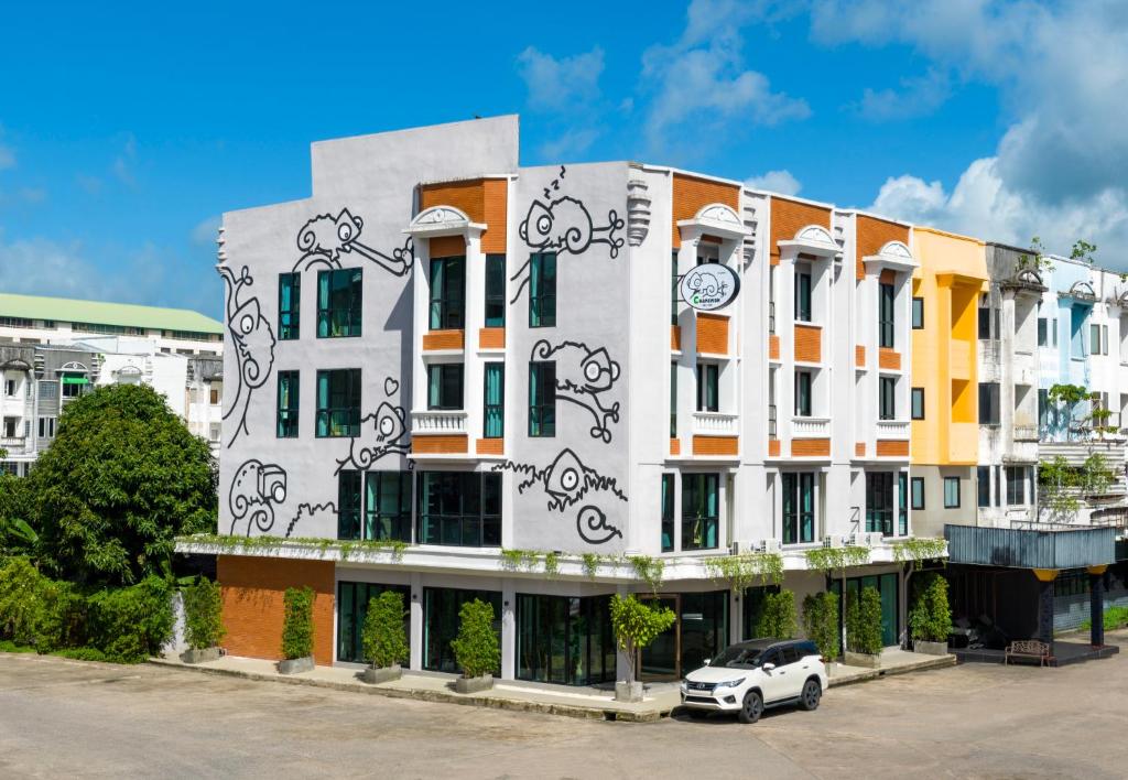 普吉市的住宿－Chamemon Bed Phuket Town，前面有停车位的建筑