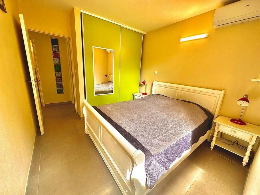 - une chambre avec un lit dans une pièce aux murs jaunes dans l'établissement Paisible T2 sur Sainte-Marie, à Sainte-Marie
