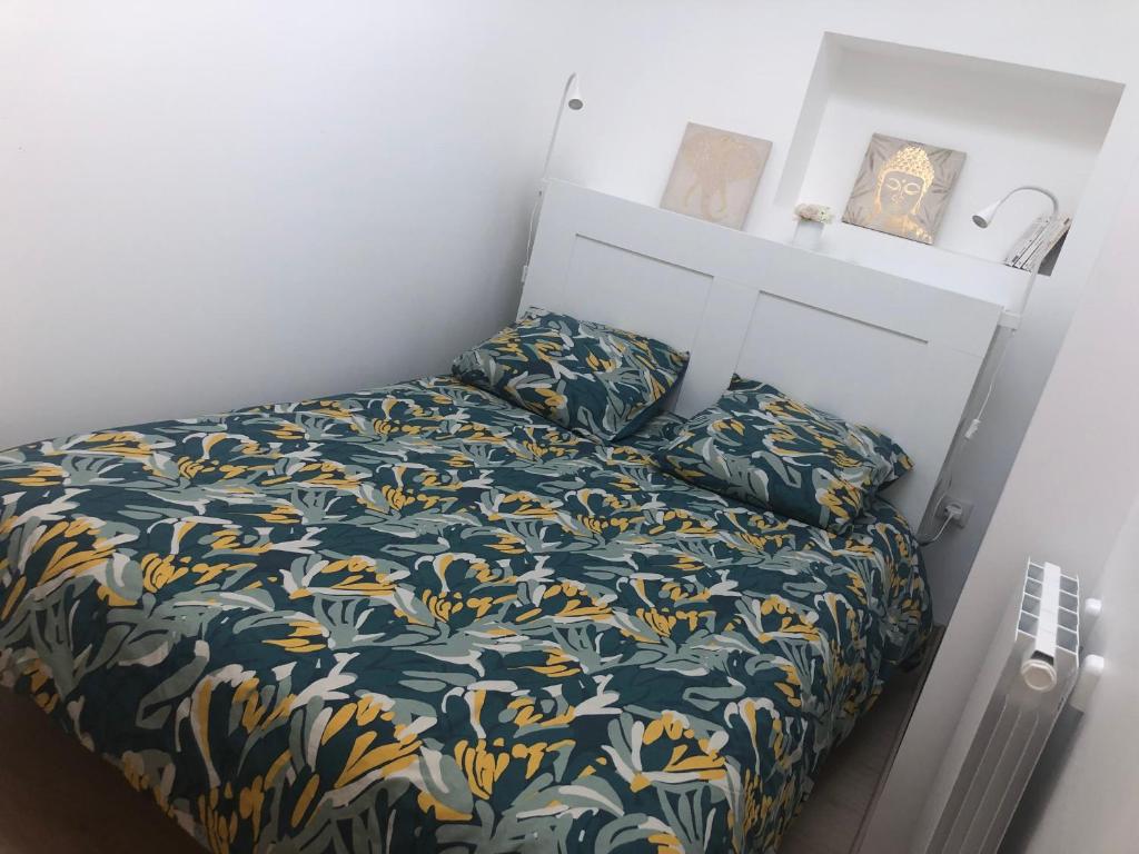 niewielka sypialnia z łóżkiem z narzutą kwiatową w obiekcie Appartement paisible proche centre ville w mieście Bron