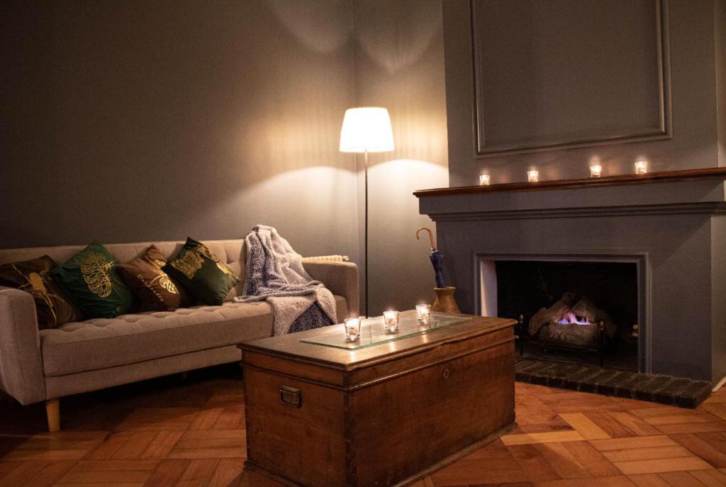 a living room with a couch and a fireplace at Casa Ribera Hotel Providencia in Santiago
