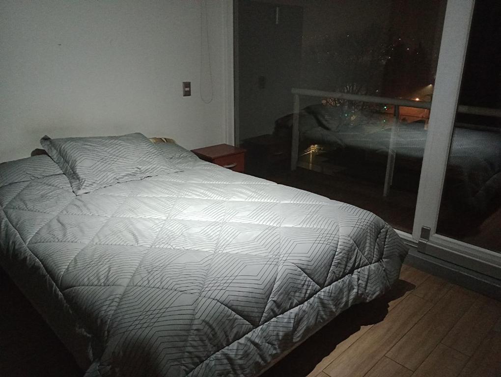 - un lit non aménagé dans une chambre avec fenêtre dans l'établissement Sur de chile, à Temuco