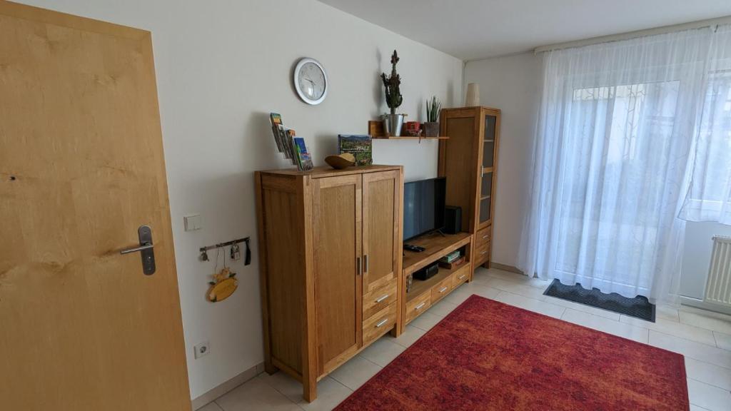 uma sala de estar com televisão e um armário em FeWo Apland em Landau in der Pfalz