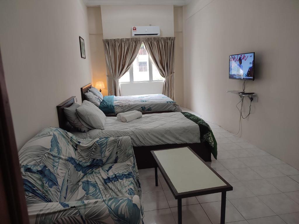 a small room with two beds and a couch at Sofea Inn Bukit Merah - Laketown D6529 in Kampong Selemat