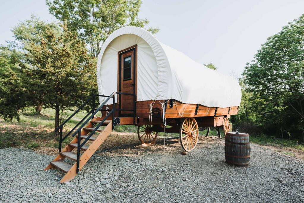 a small yurt with a ladder and a wagon at Heated & AC Full Bathroom Covered Wagon in Penn Yan
