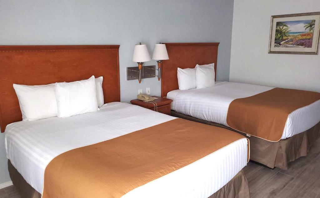 a hotel room with two beds and two lamps at Coratel Inn & Suites by Jasper New Braunfels IH-35 EXT 189 in New Braunfels