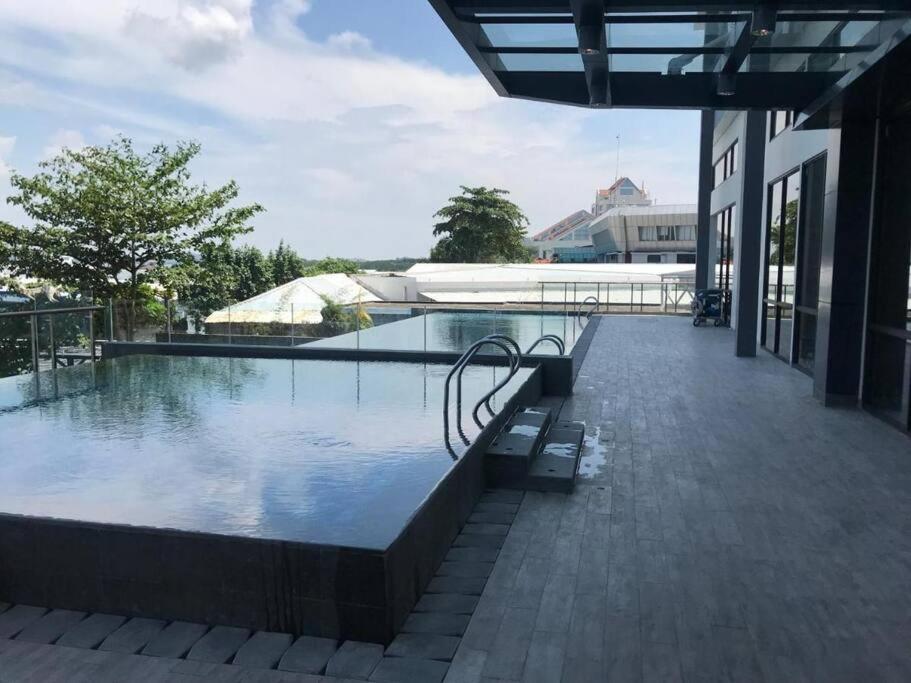 una piscina con un banco junto a un edificio en One Residence 2 Bedroom Sea View, en Batam Centre
