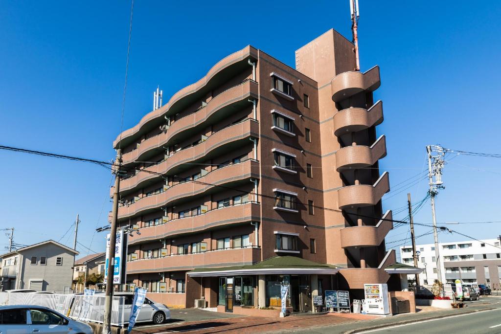 um edifício castanho alto na esquina de uma rua em ルグランみしま em Hamamatsu