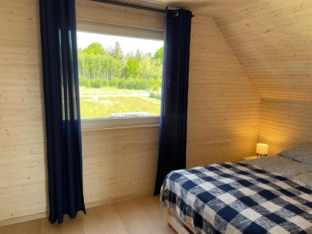 sypialnia z oknem i łóżkiem w pokoju w obiekcie PoProstuDomki w mieście Niechorze