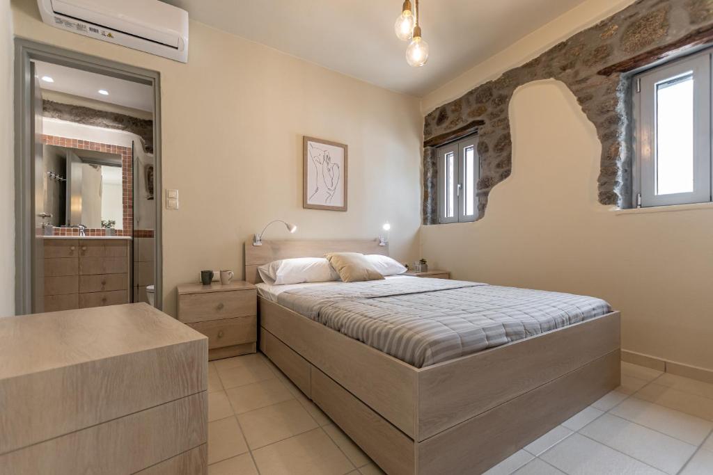 a bedroom with a large bed and a bathroom at Marousas Place in Agkidia