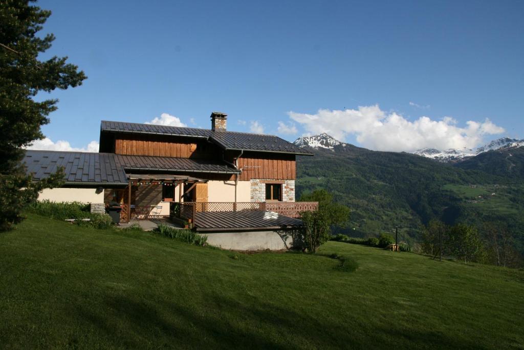 a house on a hill with mountains in the background at Les Marm'hôtes in La Côte-dʼAime