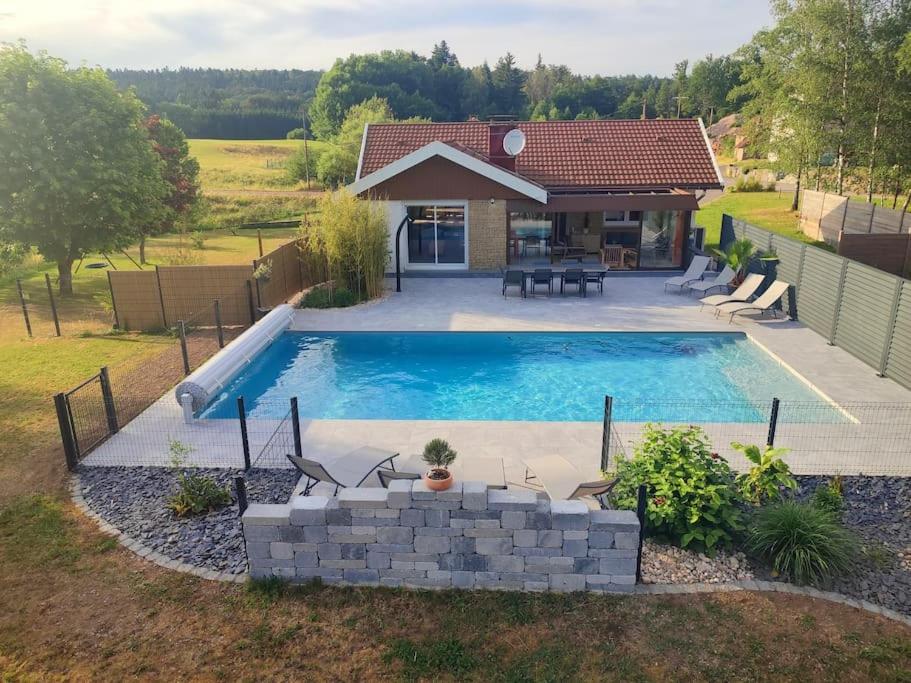 a swimming pool in front of a house at Maison avec piscine, jacuzzi et sauna in Saint-Nabord