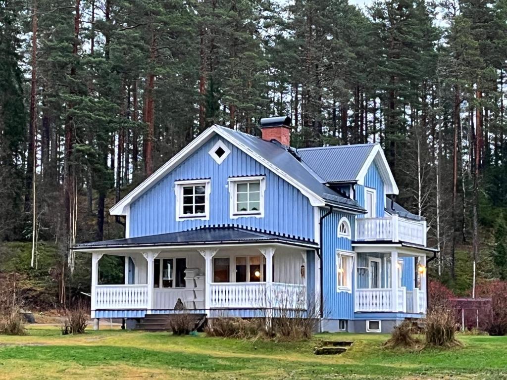 una casa azul en medio de un campo en Gård Mörbacka Bed & Breakfast en Mörbacka