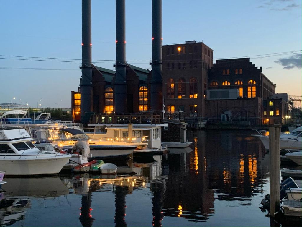 a group of boats docked in a harbor with a factory at Studio 54 Themed Boat St. Tropez in Providence