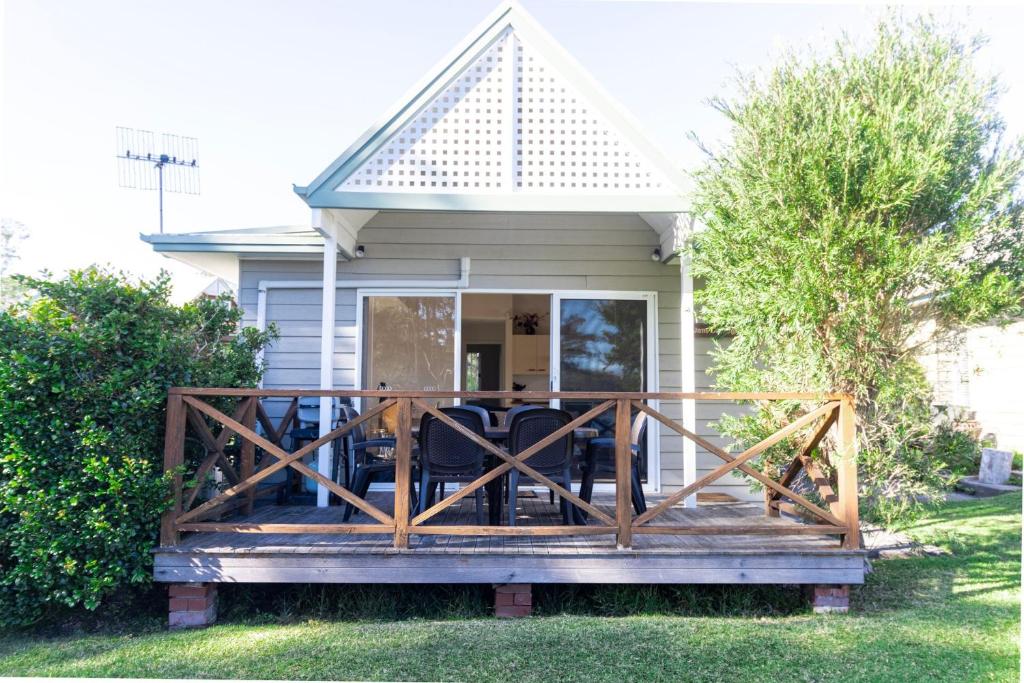 una terraza de madera frente a una casa en Berrara Lagoon Front Chalet en Berrara