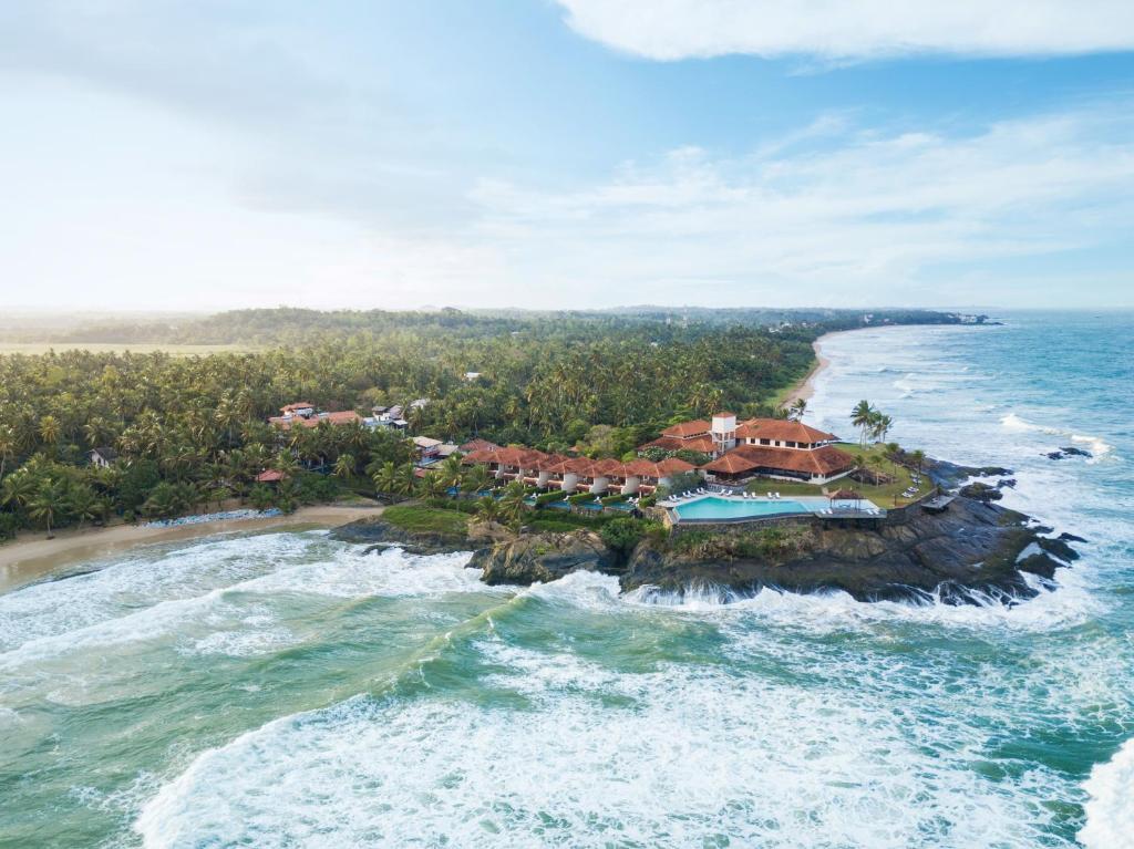 eine Luftansicht eines Resorts auf einer Insel im Meer in der Unterkunft Jetwing Saman Villas in Bentota