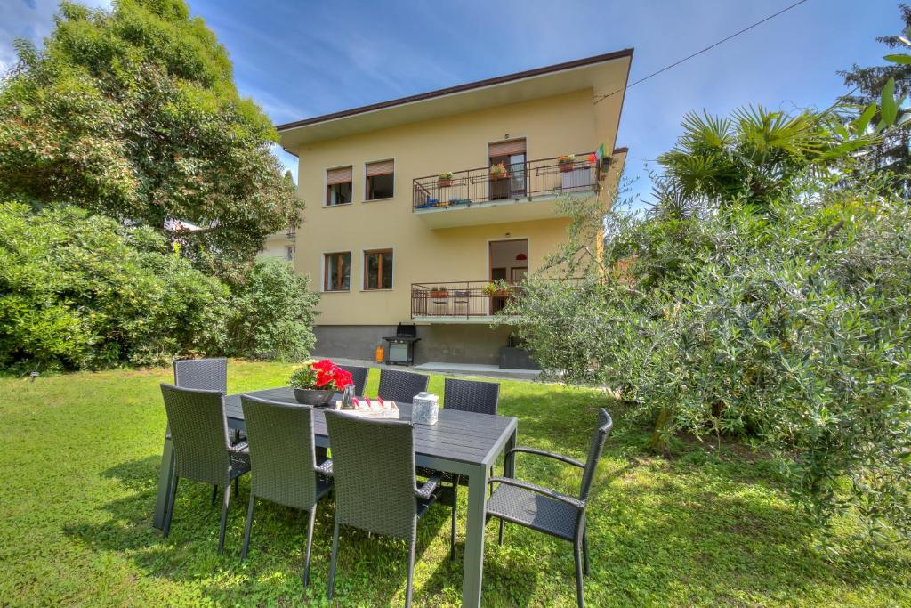une table et des chaises devant une maison dans l'établissement The Bon'Ora Apartment - Happy Rentals, à Riva del Garda