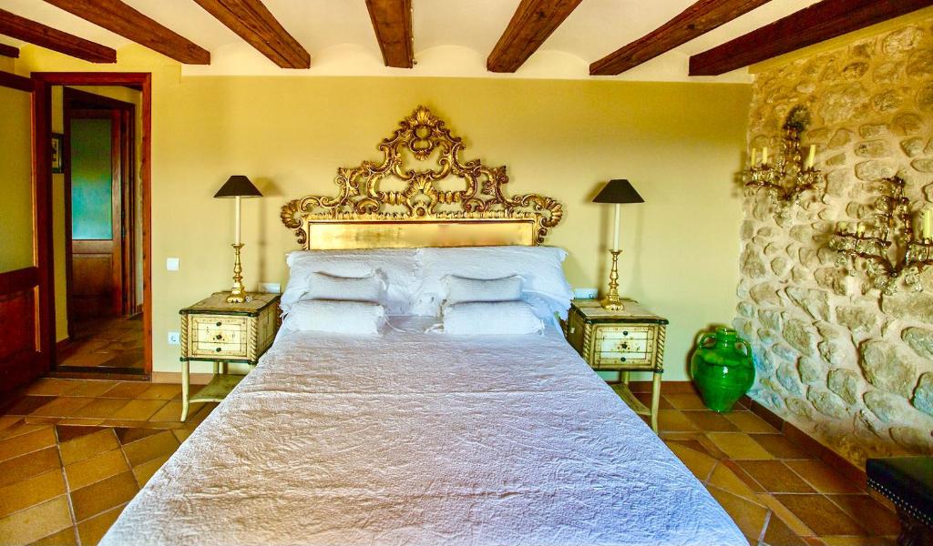 1 dormitorio con 1 cama grande y 2 mesitas de noche en Casa Rumbet, en Horta de Sant Joan