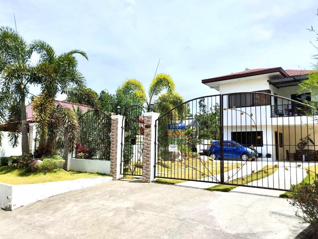 una puerta frente a una casa con palmeras en Casa LeoMa en Cavite