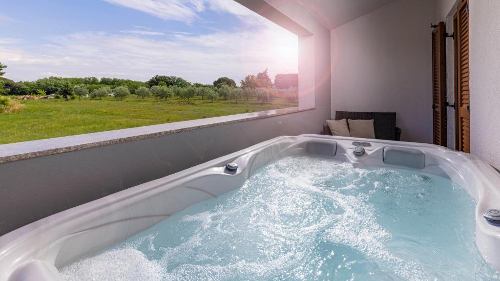 a bath tub in a room with a large window at Val Piana in Savudrija