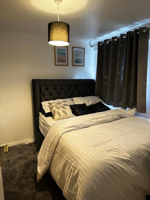 a bedroom with a bed with a black headboard at Lovely room in South London in Addington