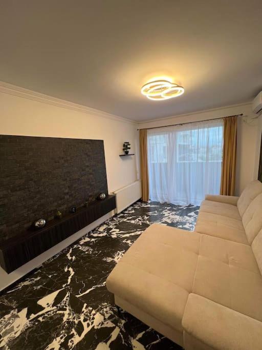 sala de estar con sofá y ventana grande en Luxury Apartments by Patrik, en Oradea