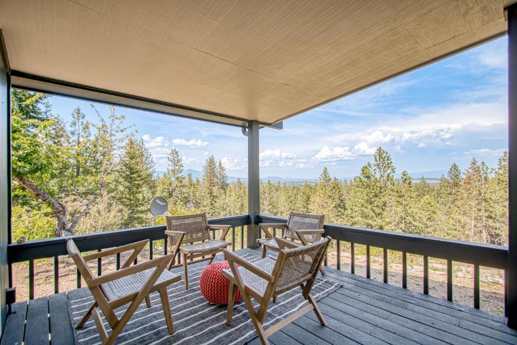 a deck with chairs and a table with a view at Tanglewood Retreat in Post Falls