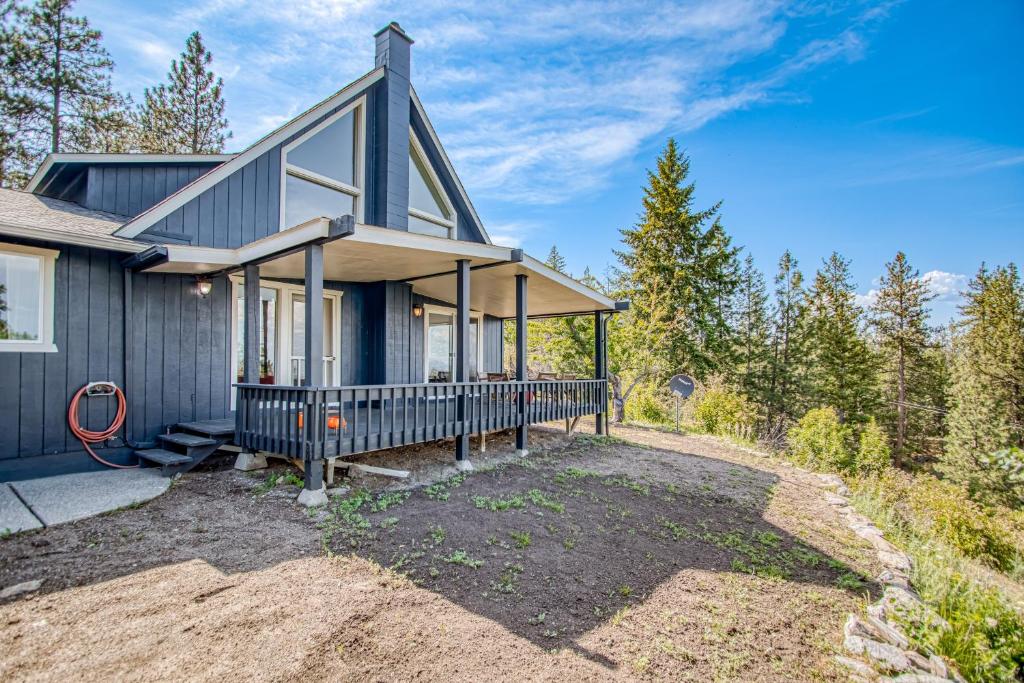 una casa en el bosque con un gran porche en Tanglewood Retreat, en Post Falls